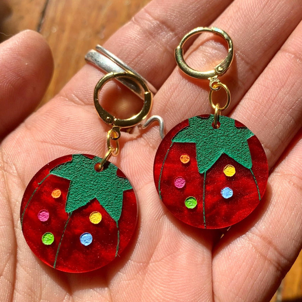 Person holding Tomato Pin Cushion Earrings.