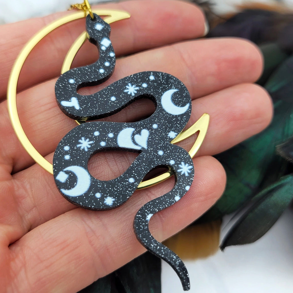 Snake Moon Necklace in hand.