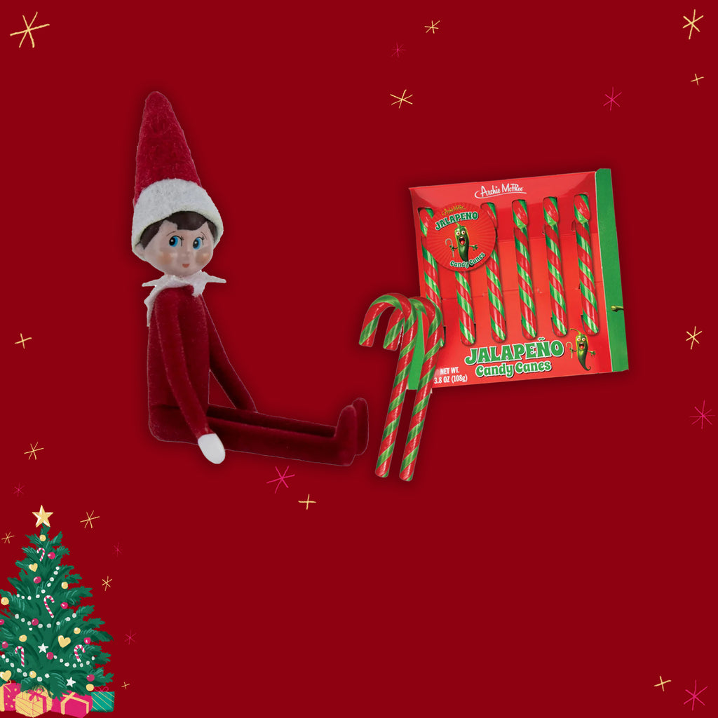 Elf on the shelf with candy canes and a box of jalapeno candy canes on a red background.
