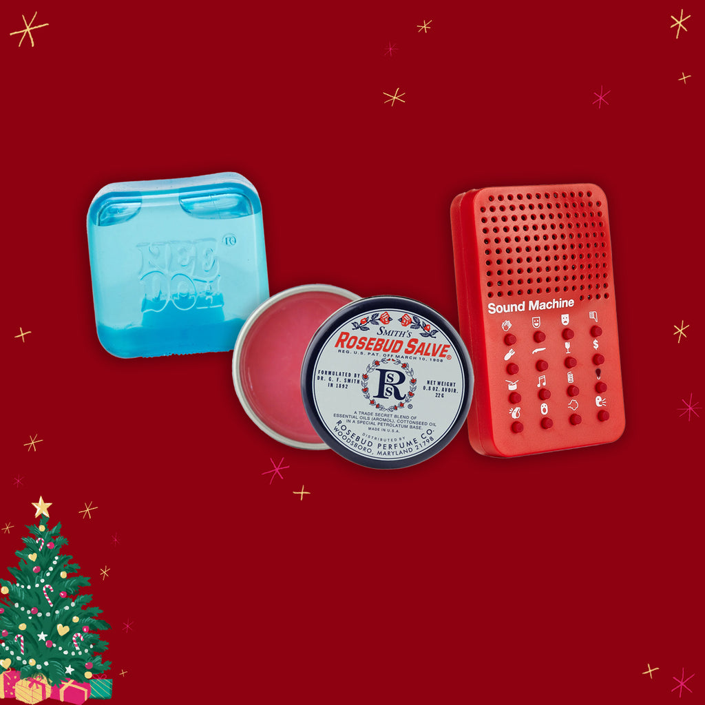 Rosebud Salve with blue lid, red container, and 'Sound Machine' device on a red background with Christmas decorations.