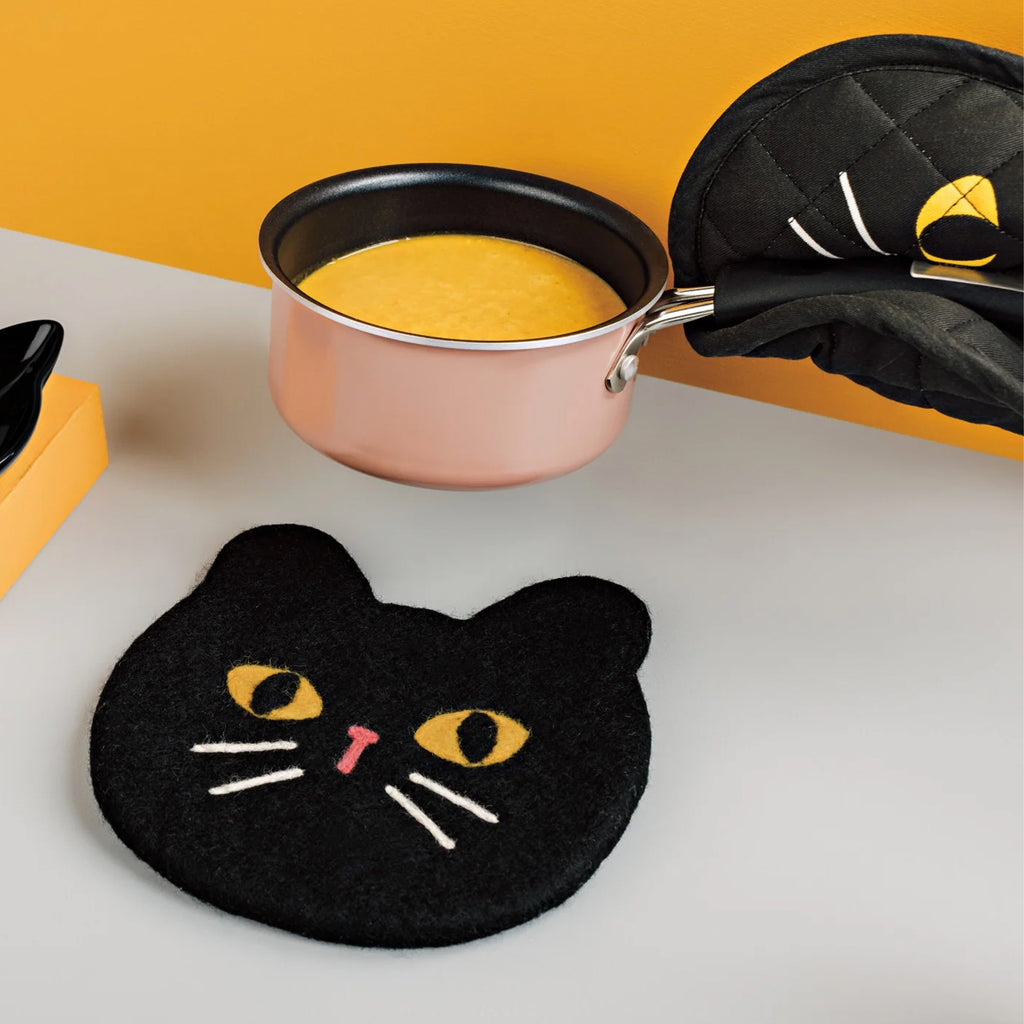 Black Cat Felted Wool Trivet on table.