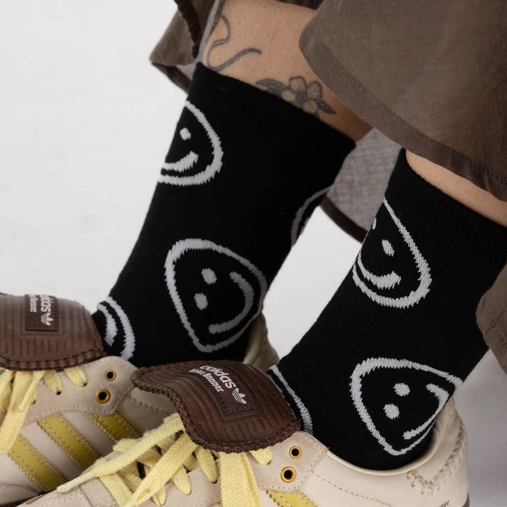 Black Happy Face Crew Socks in shoes.