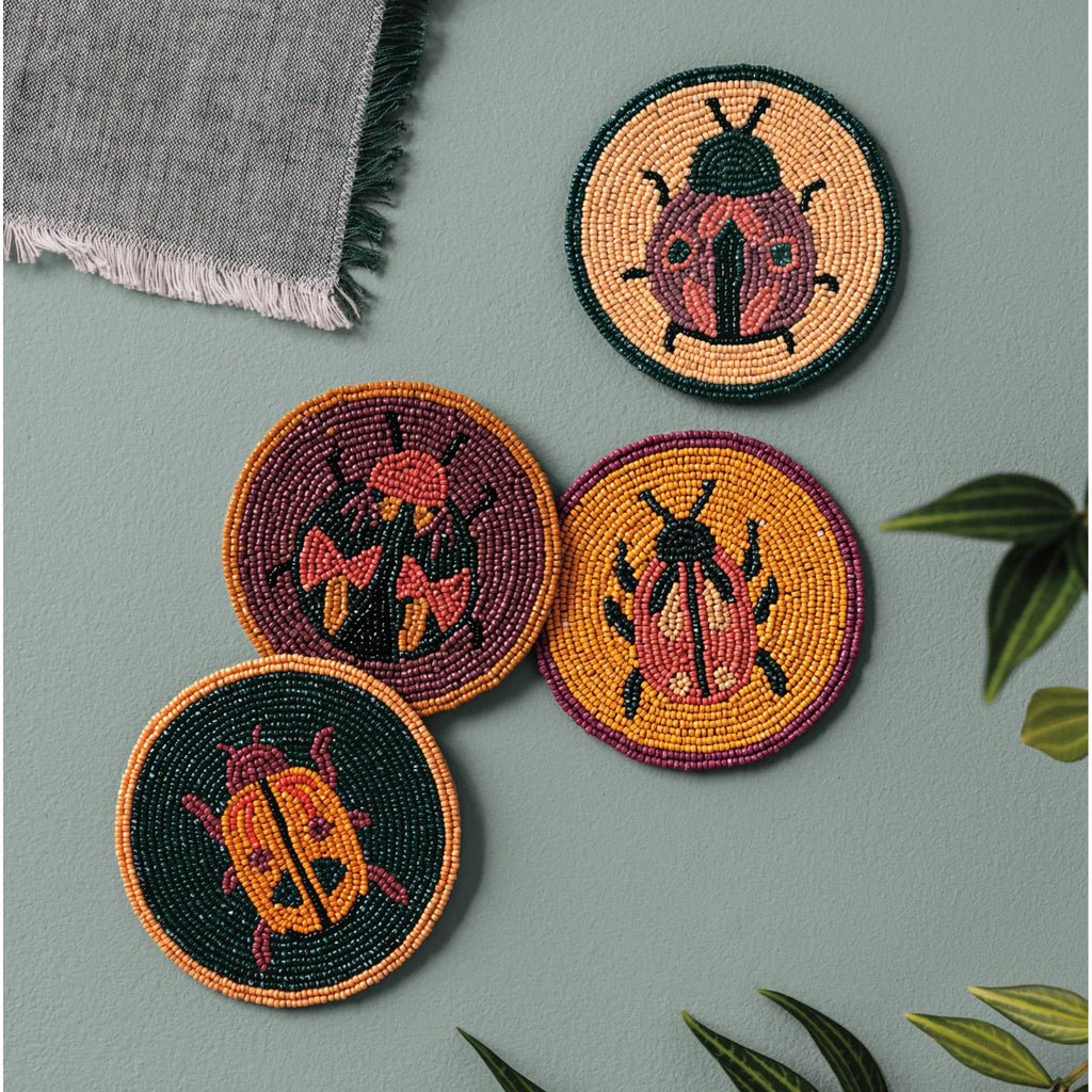 Coaster Set/4 Beaded Amulet on table.