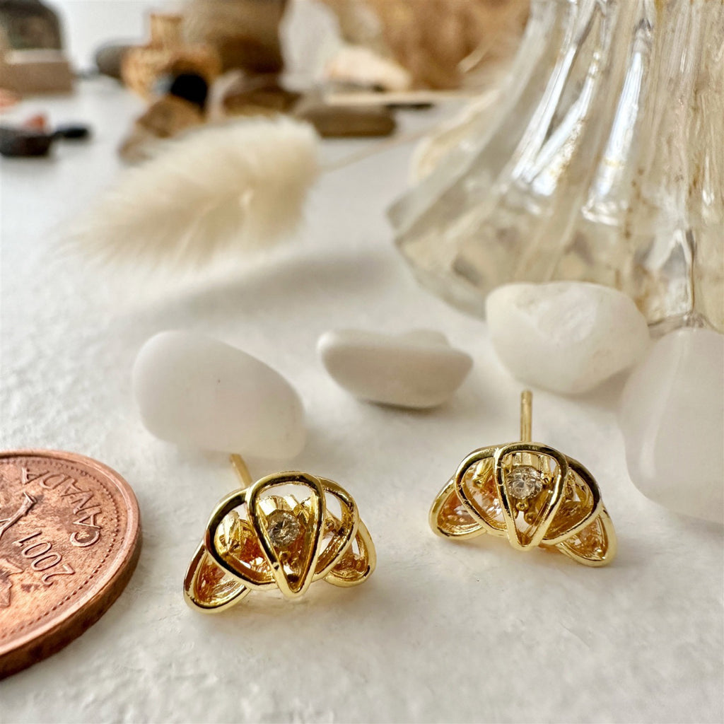 Croissant Rhinestone Stud Earrings Gold besides a penny.