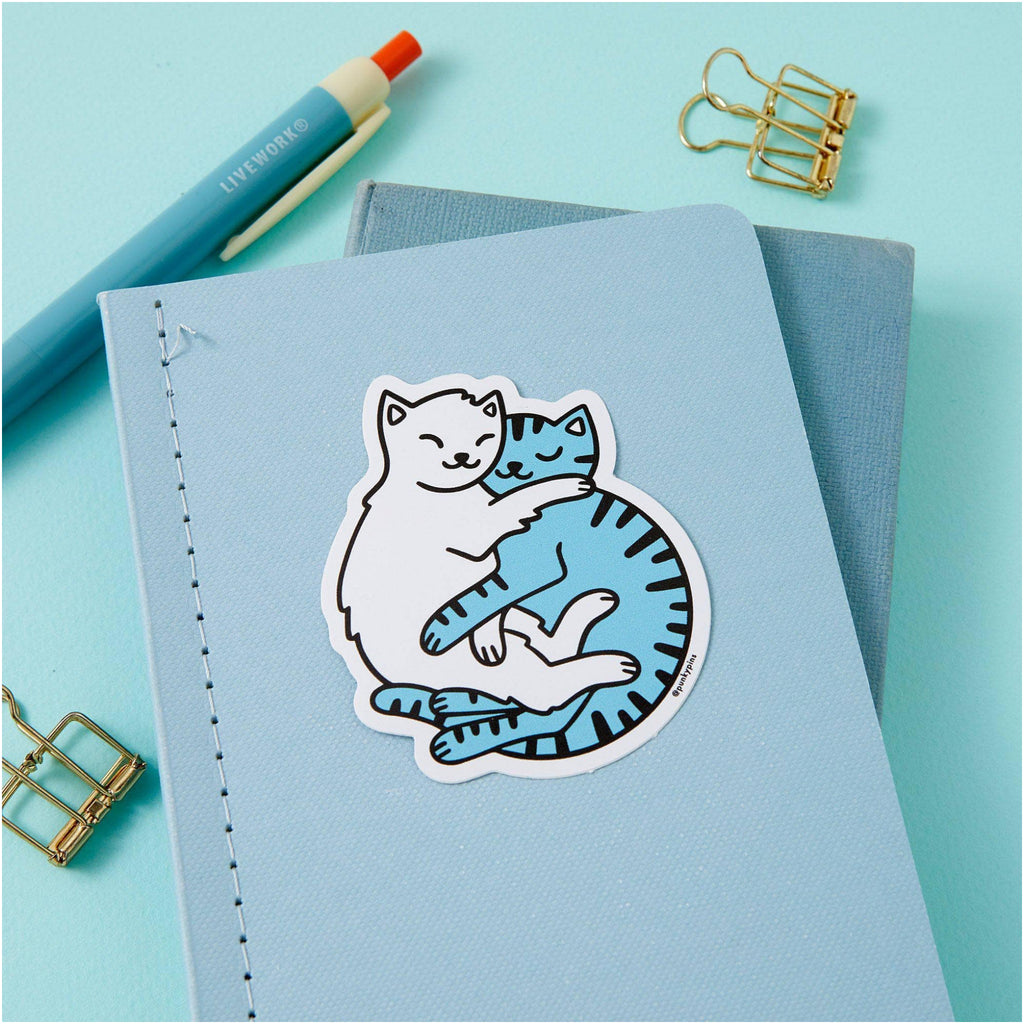 Cuddling Cats Vinyl Sticker on book.