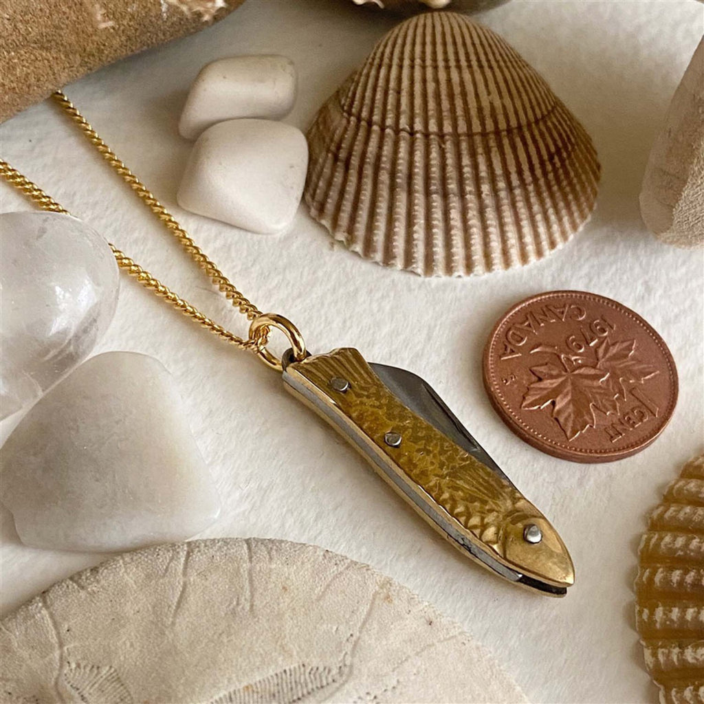Fish Pocket Knife Charm Necklace besides a pennny.
