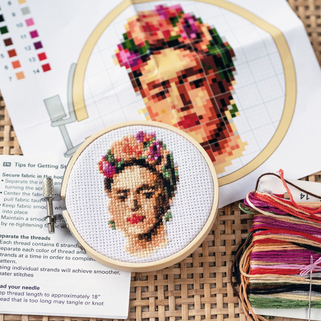 Frida Mini Cross Stitch Embroidery on table.