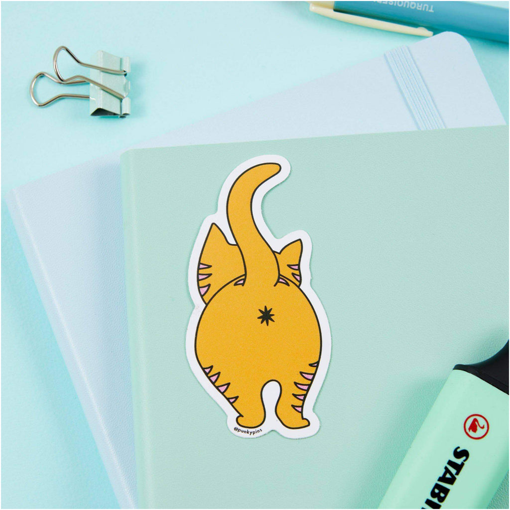 Ginger Cat Vinyl Sticker on book.