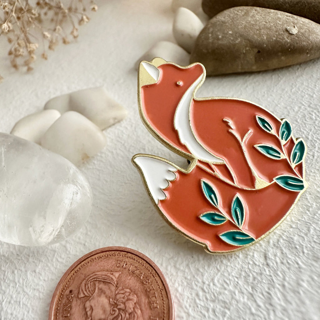 Handsome Sitting Fox Lapel Pin besides a penny.