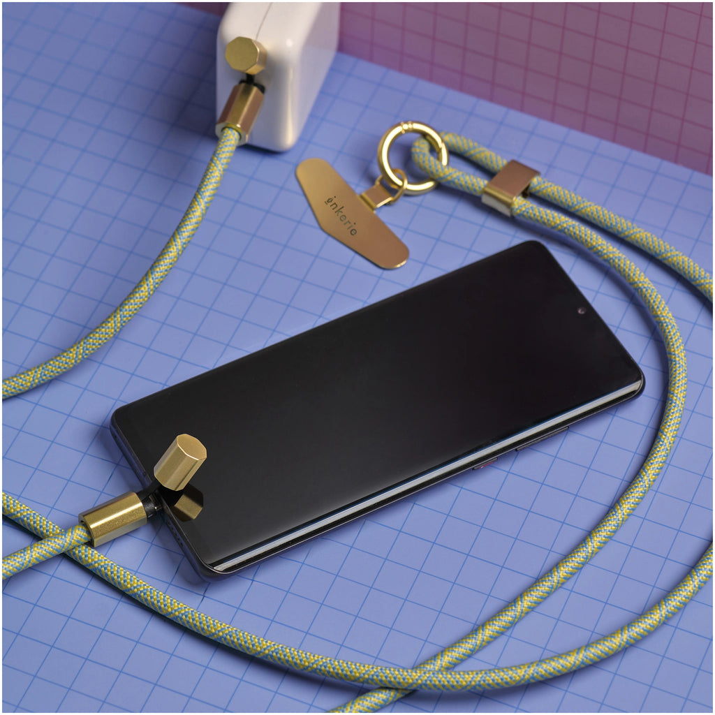 Inkerie Charge & Carry Phone Lanyard Green on table.