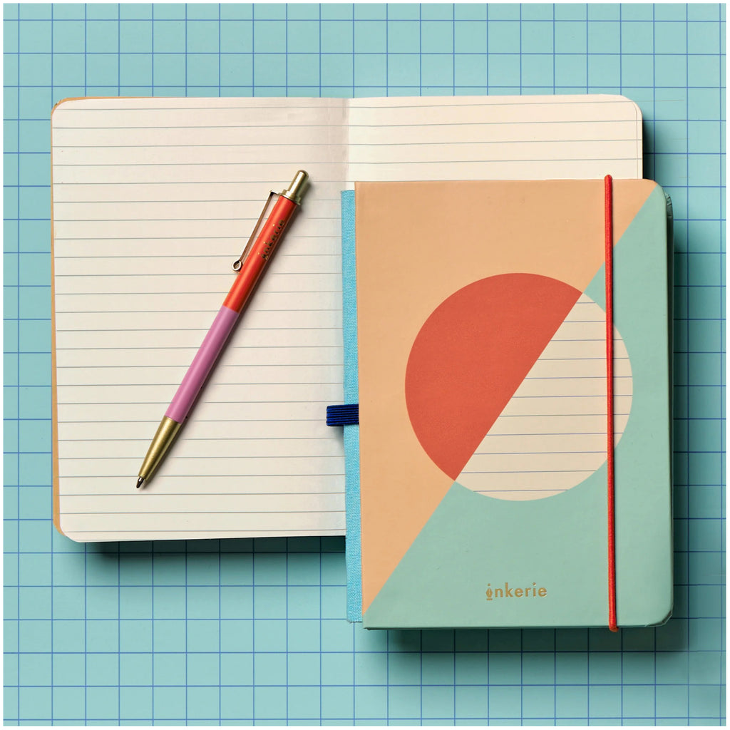 Inkerie Lined Mini Notebook & Pen on table.