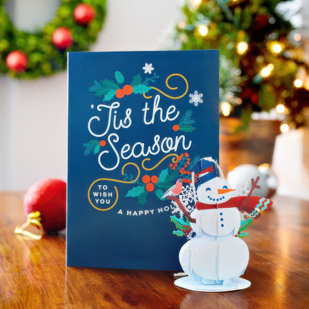 Lovepop Snowman Card With Ornament on table.
