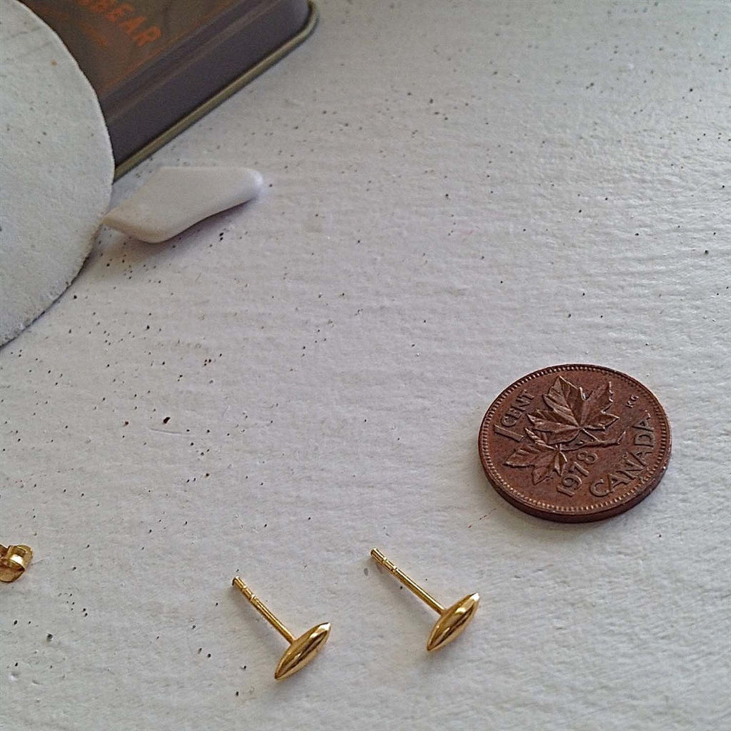 Minimalist Stud Earrings in Gold Vermeil besides a penny.
