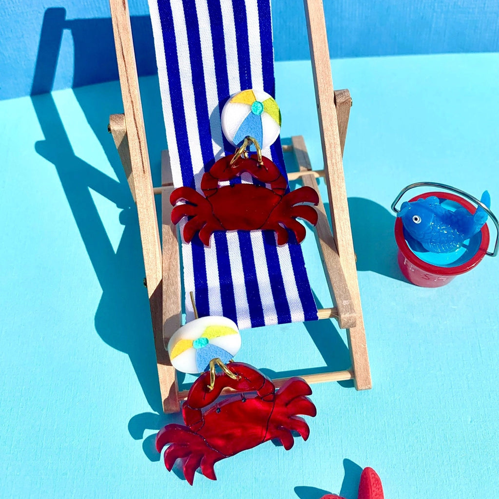 Mr. Crab Earrings on lawn chair.