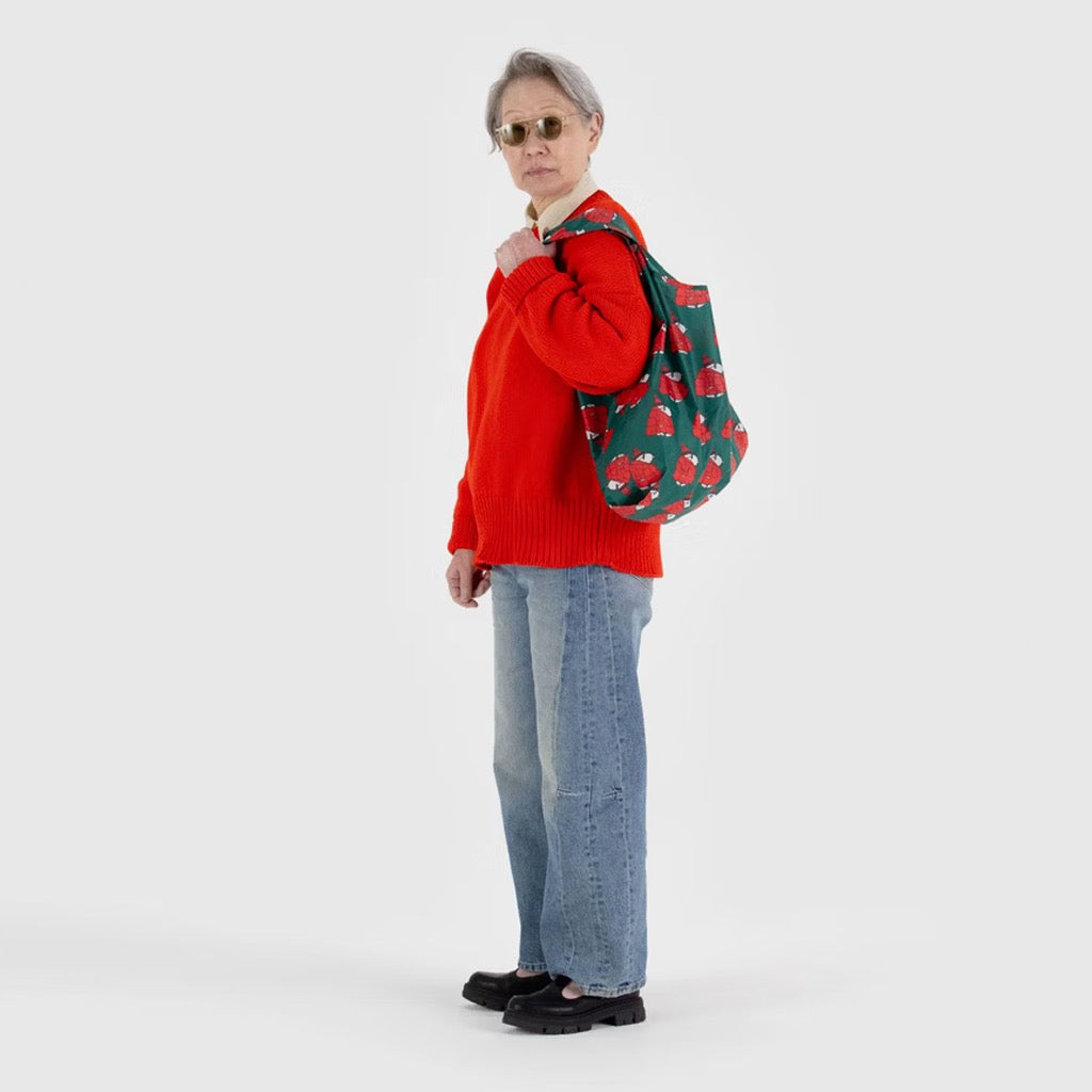 Person holding Standard Baggu Puffer Snoopy Red.