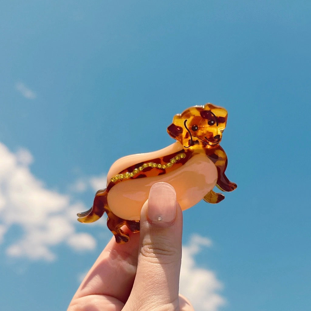 Person holding Weenie Hotdog Hair Clip.