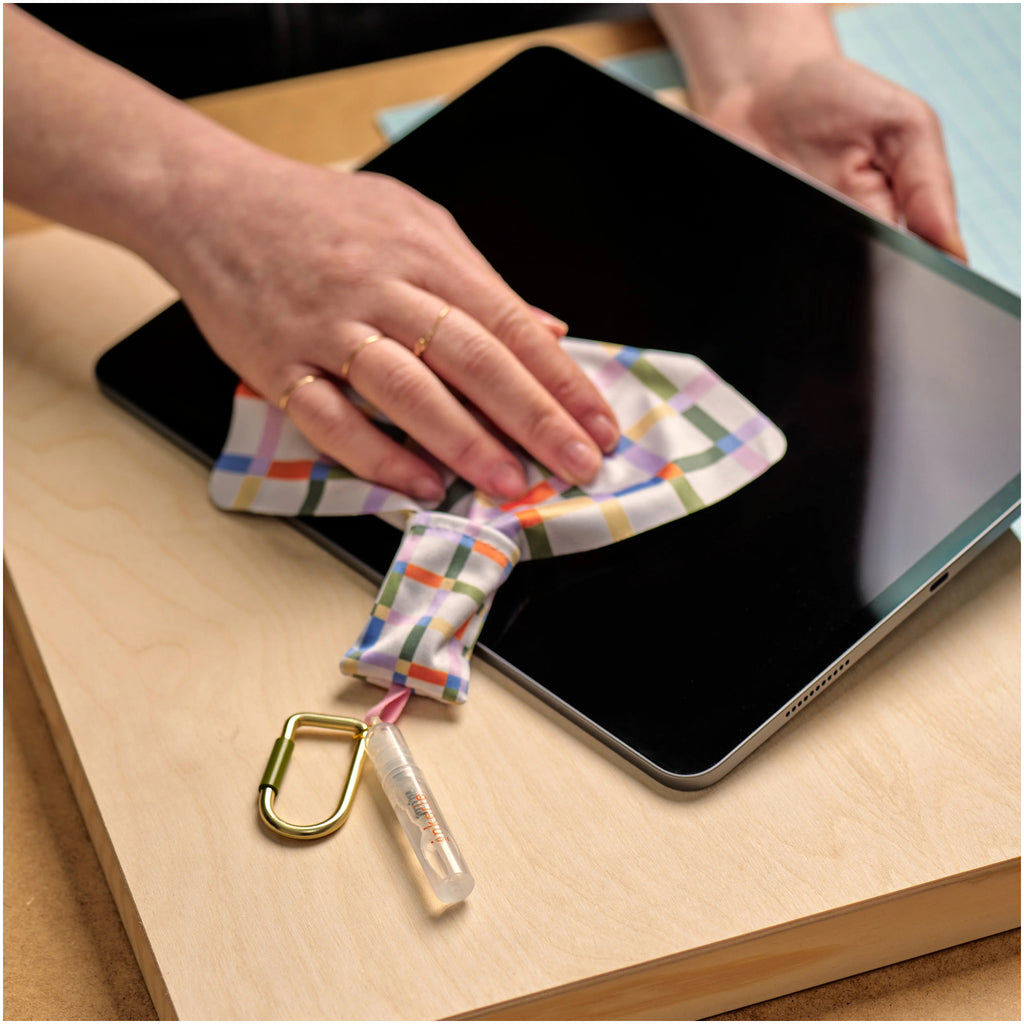 Person using Inkerie On-The-Go Len & Screen Cleaning Kit.