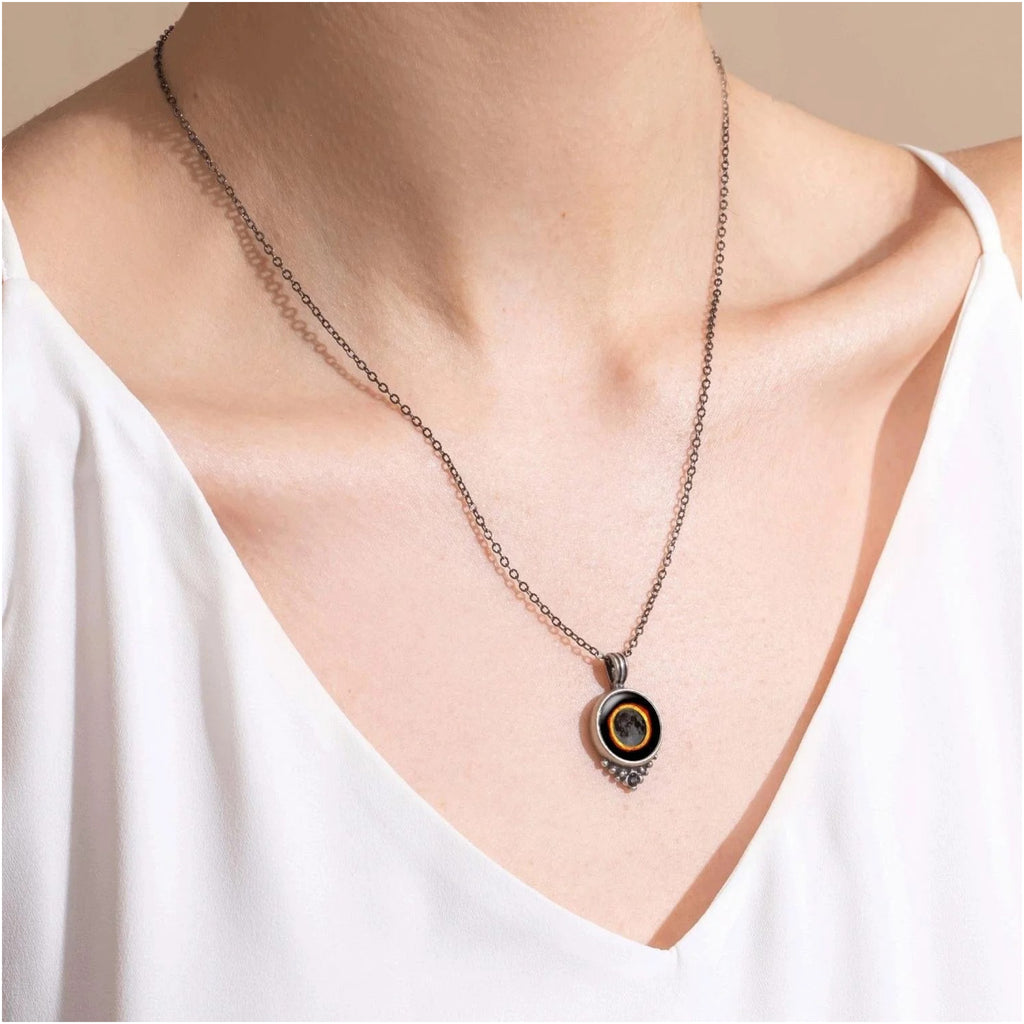 Person wearing Moon Necklace With Black Crystal Solar Ecliipse.