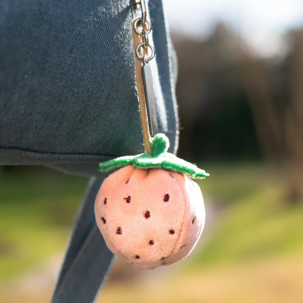 Pink Strawberry Bag Charm being used.