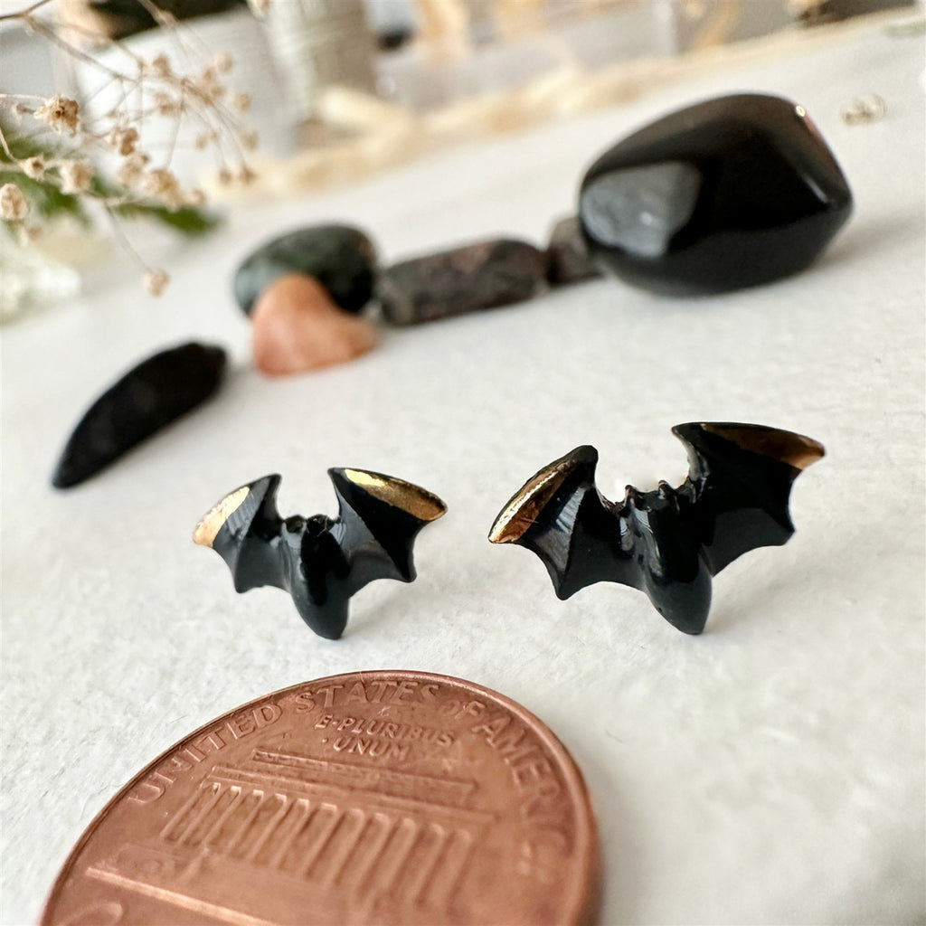 Porcelain Bat Stud Earrings besides a penny.