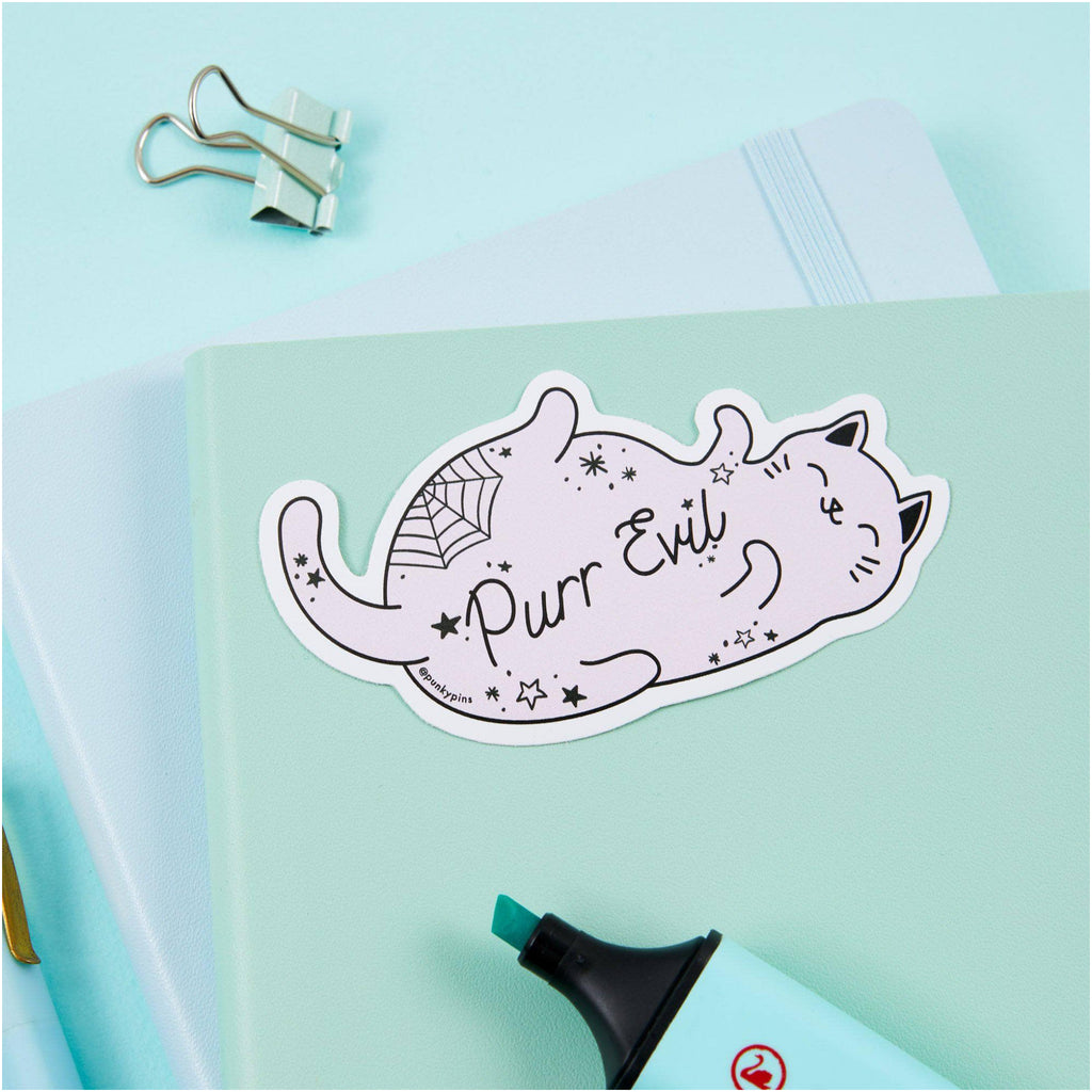 Purr Evil Cat Vinyl Sticker on book.