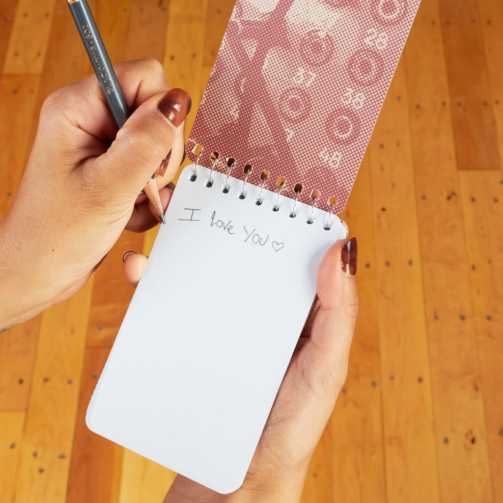 Tell Everyone Spiral Notebook being used.