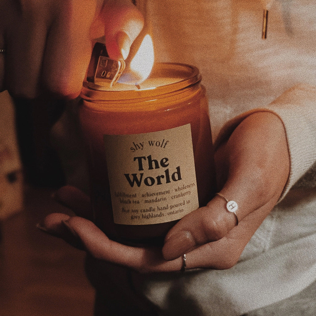 The World Tarot Soy Wax Candle being held.