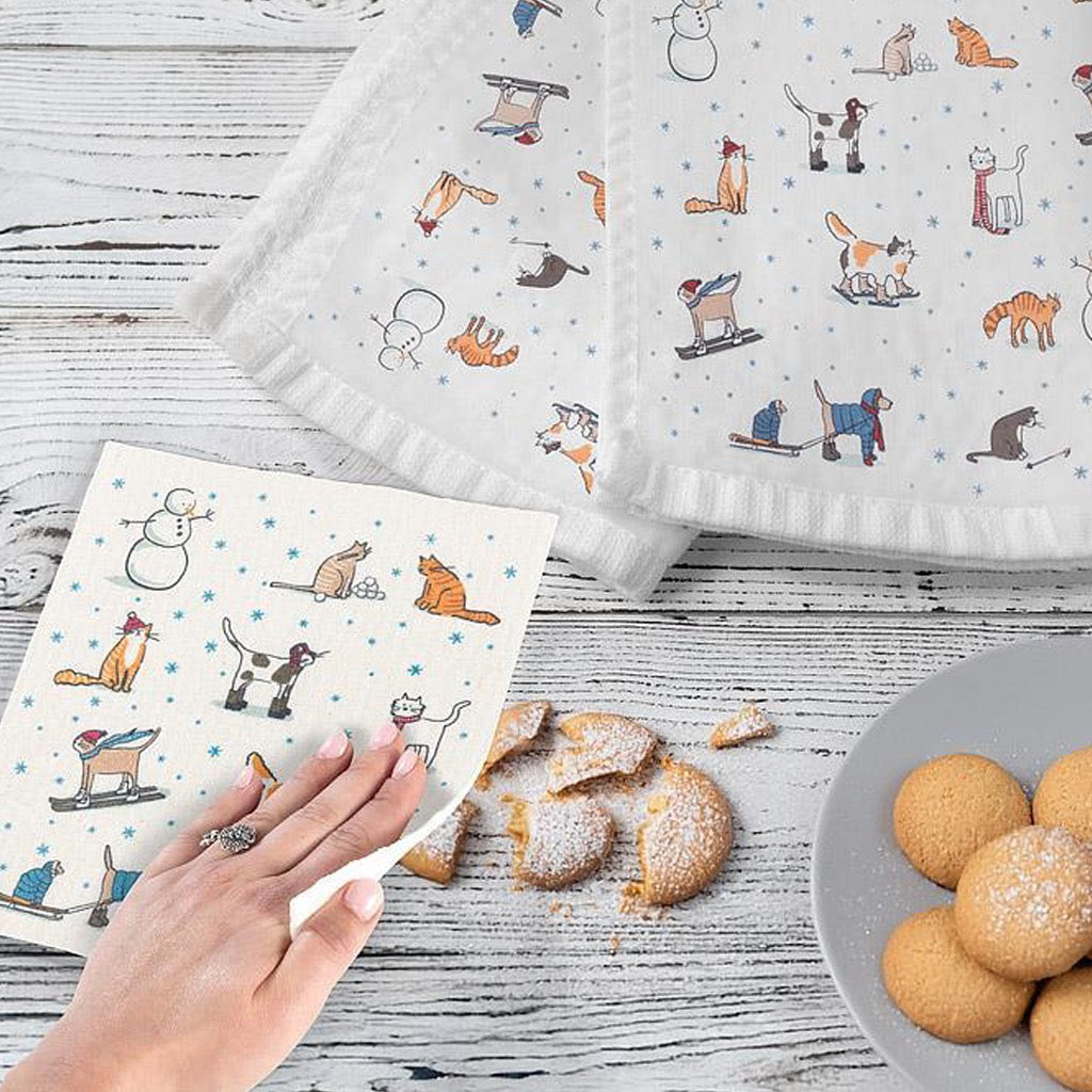 Winter Sports Cats Swedish Dishcloth on table.