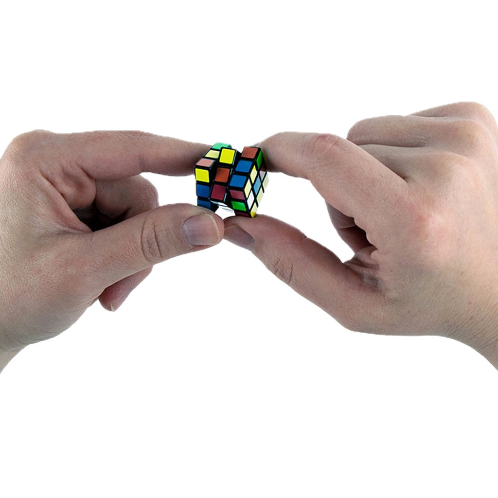 World's Smallest Rubik's 50th Anniversary in hand.