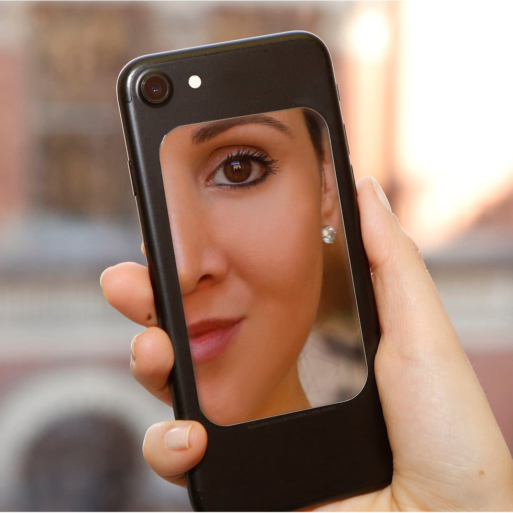 Closeup of woman looking in Phone Mirror.