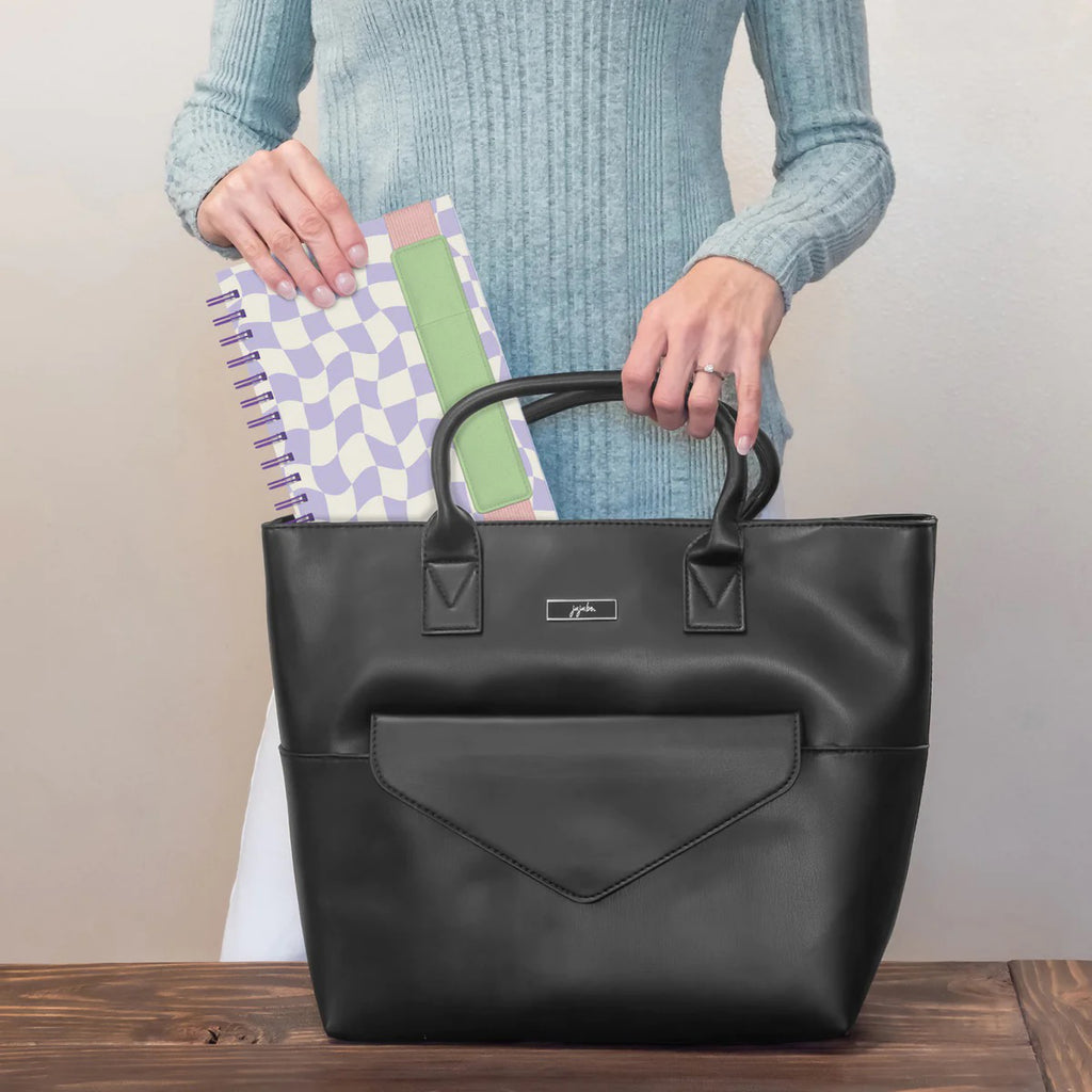 A Mirage of Thoughts Oliver Notebook being placed in bag.