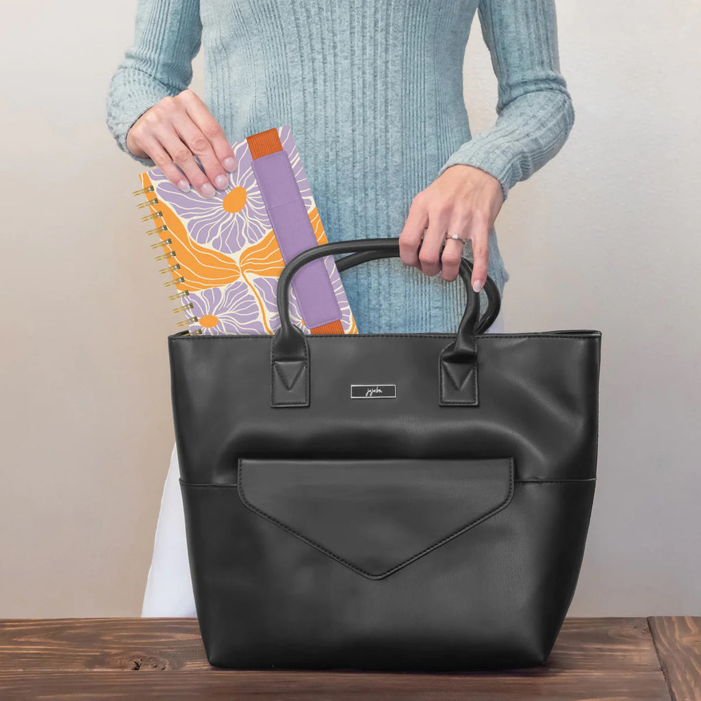 Abloom Oliver Notebook with Pen being placed into  bag.