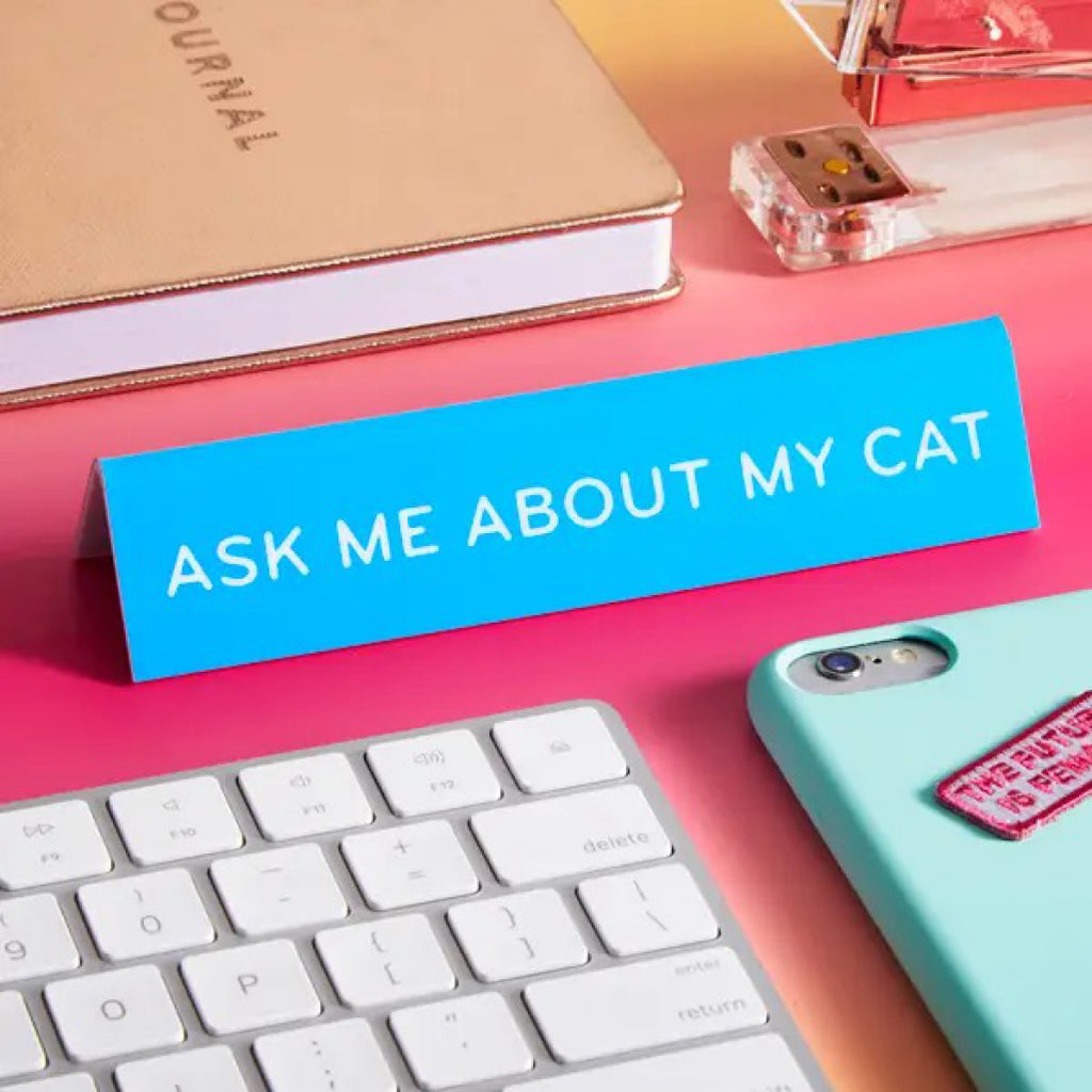 Ask Me About My Cat Desk Sign on table.