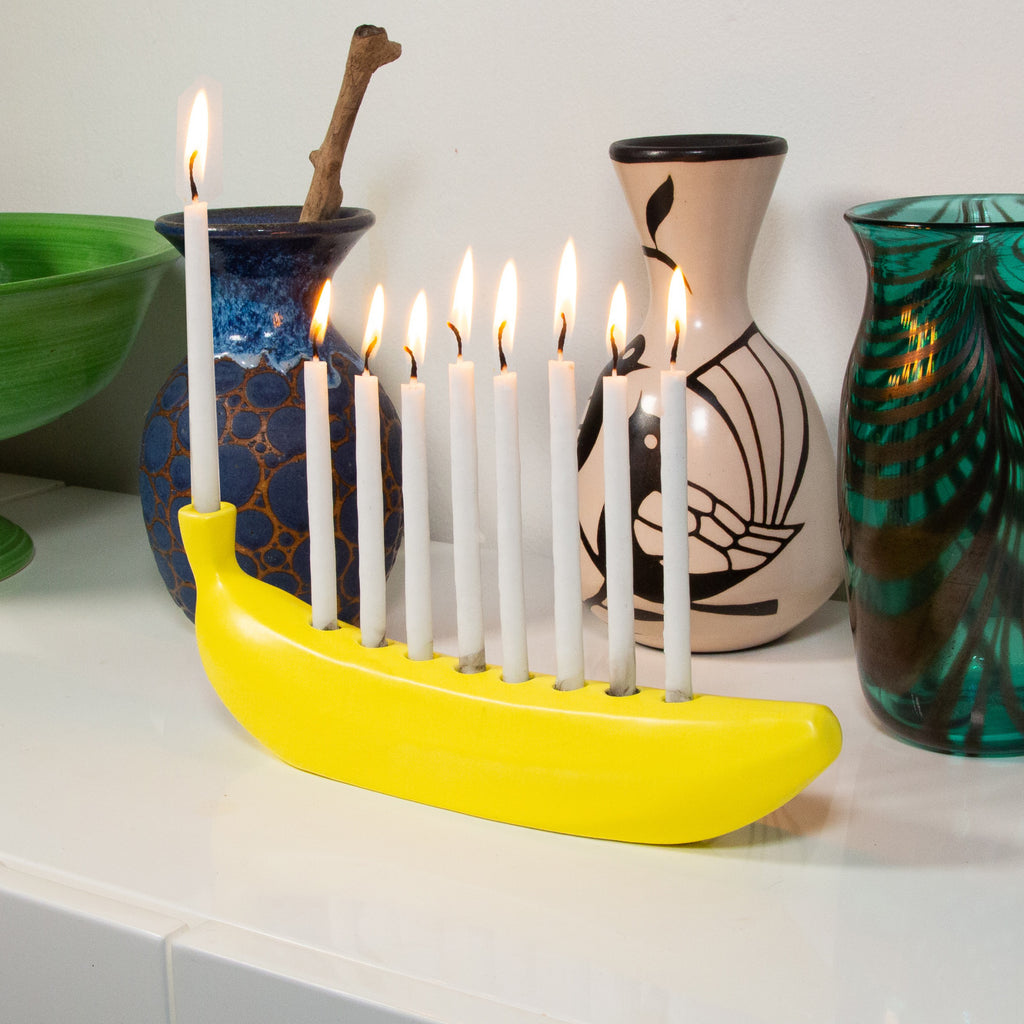 Banorah Banana Menorah with lit candles.