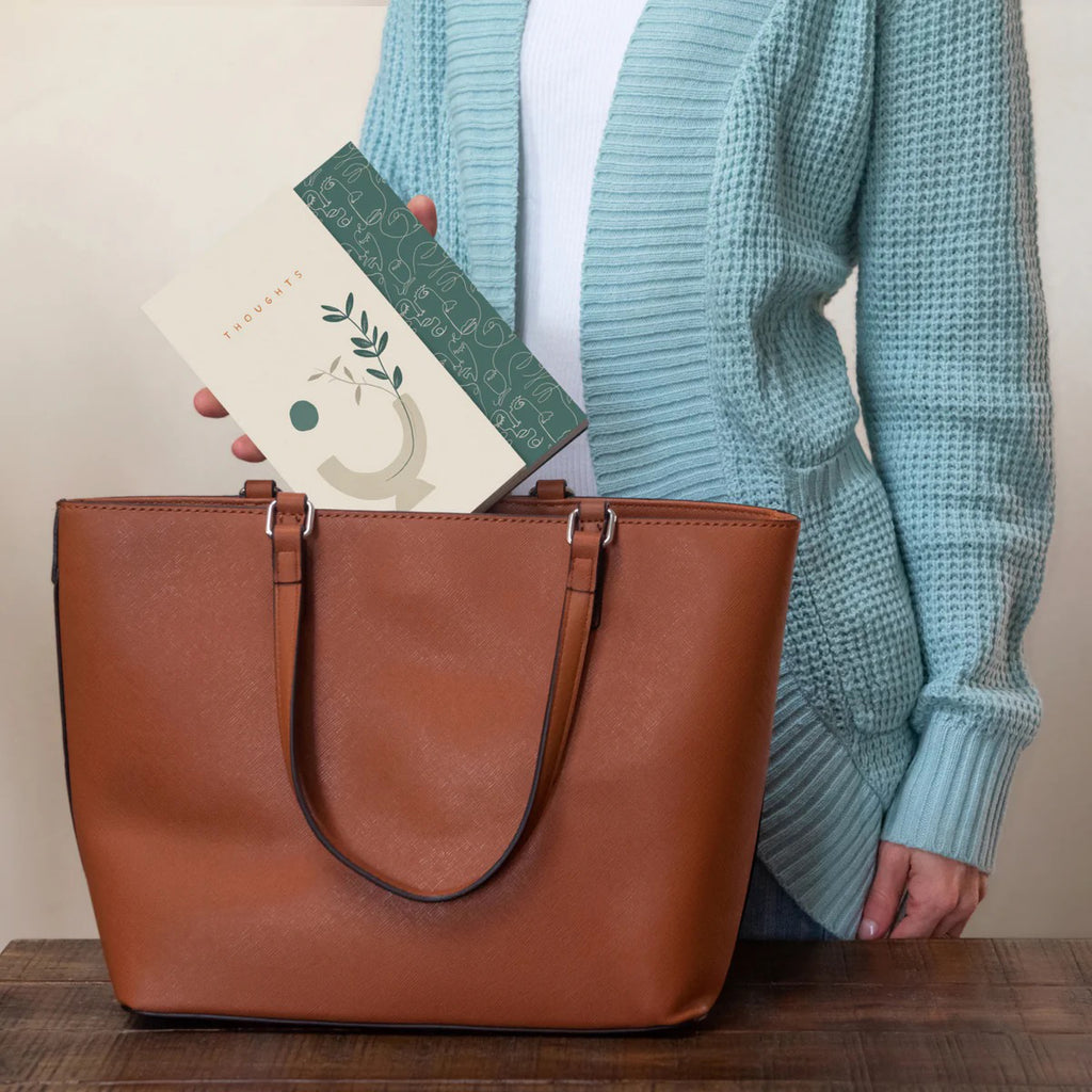 Botanical Serenity Duplex Journal being put in handbag.