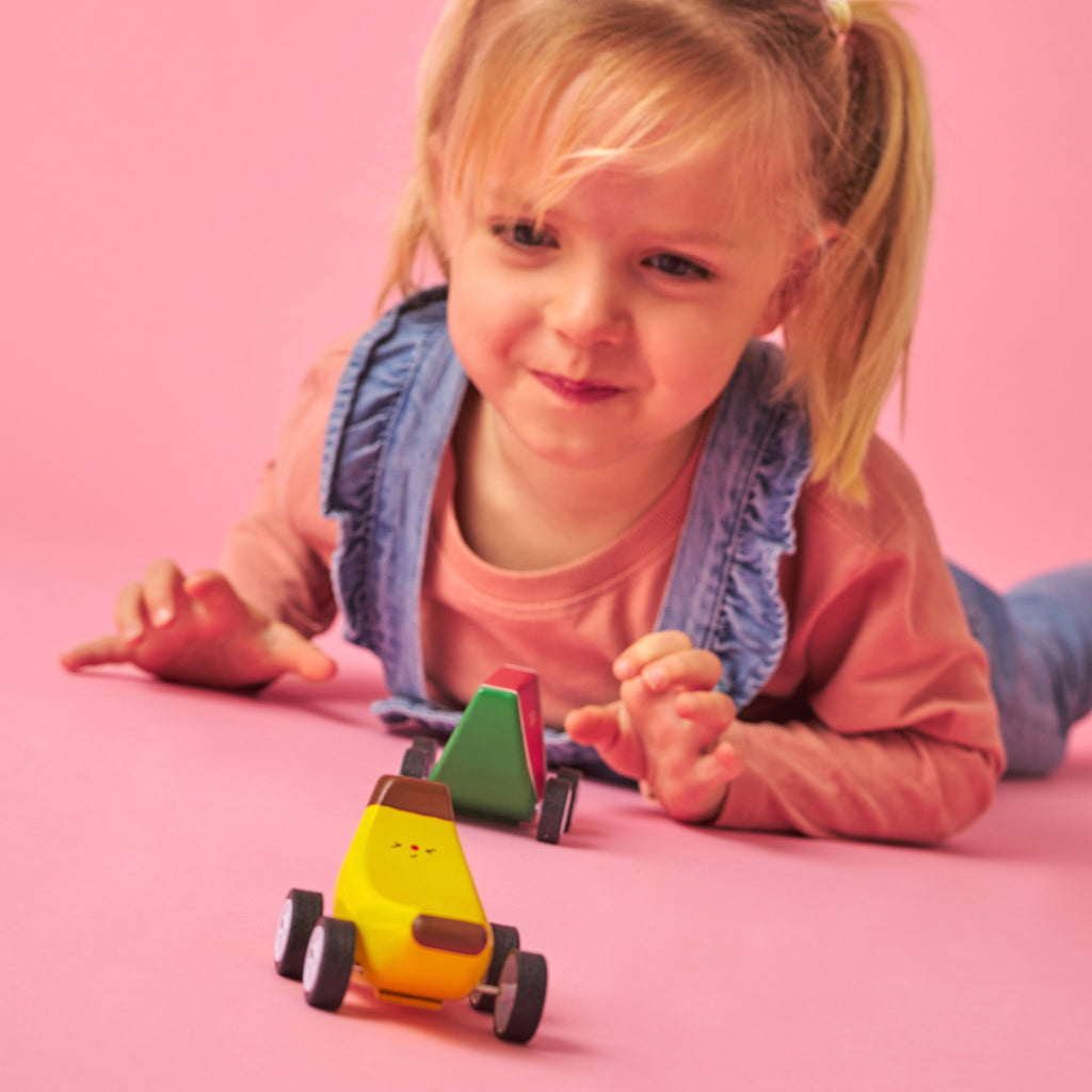 Girl playing with Fruit-Fun Pullback Cars.