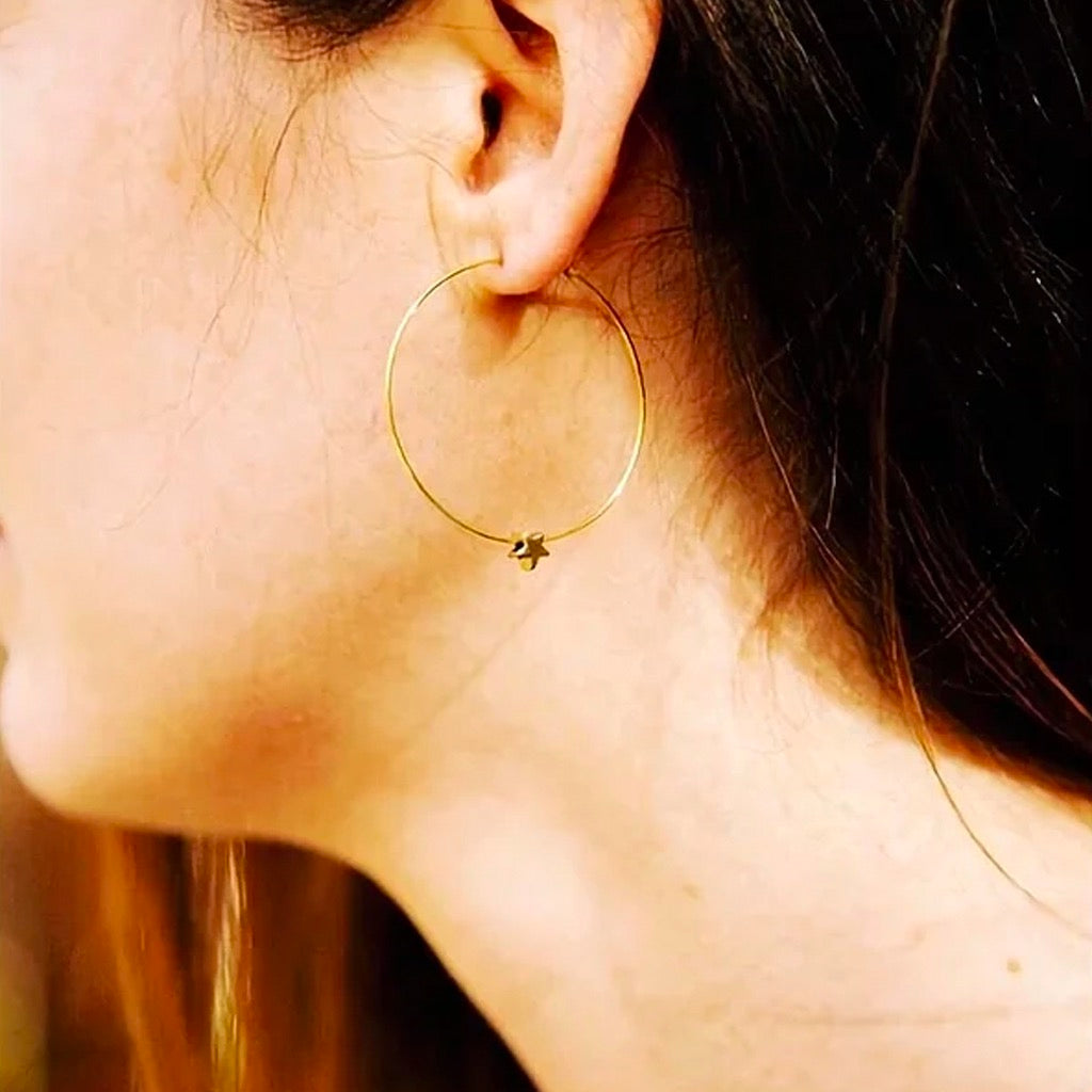 Gold Hoops with Tiny Star person wearing.