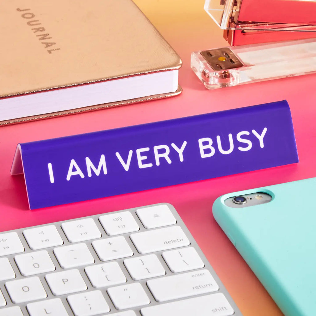 I Am Very Busy Desk Sign on table.