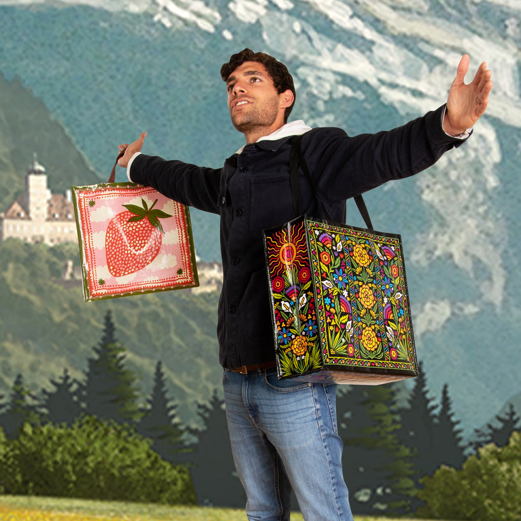 Man in mountains with Flower Fest Shopper .