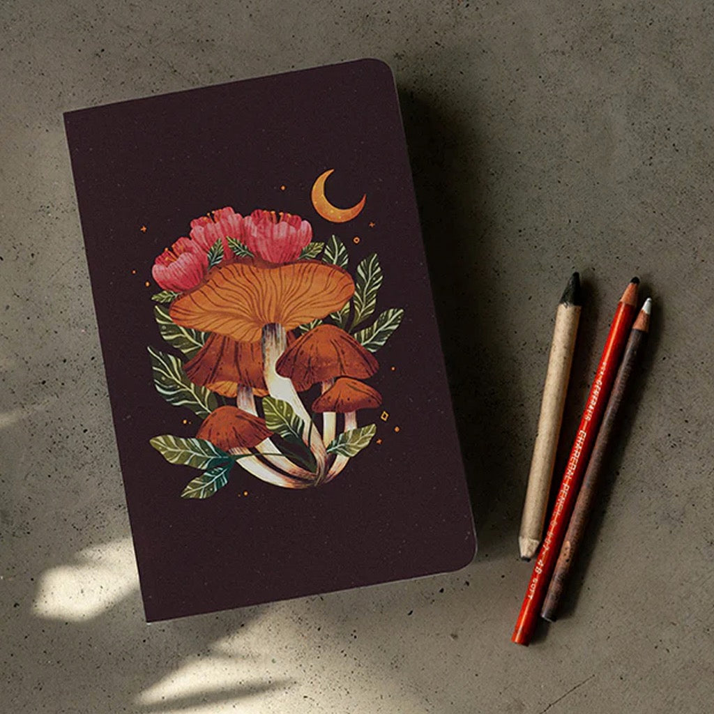 Midnight Mushrooms Layflat Notebook on table.