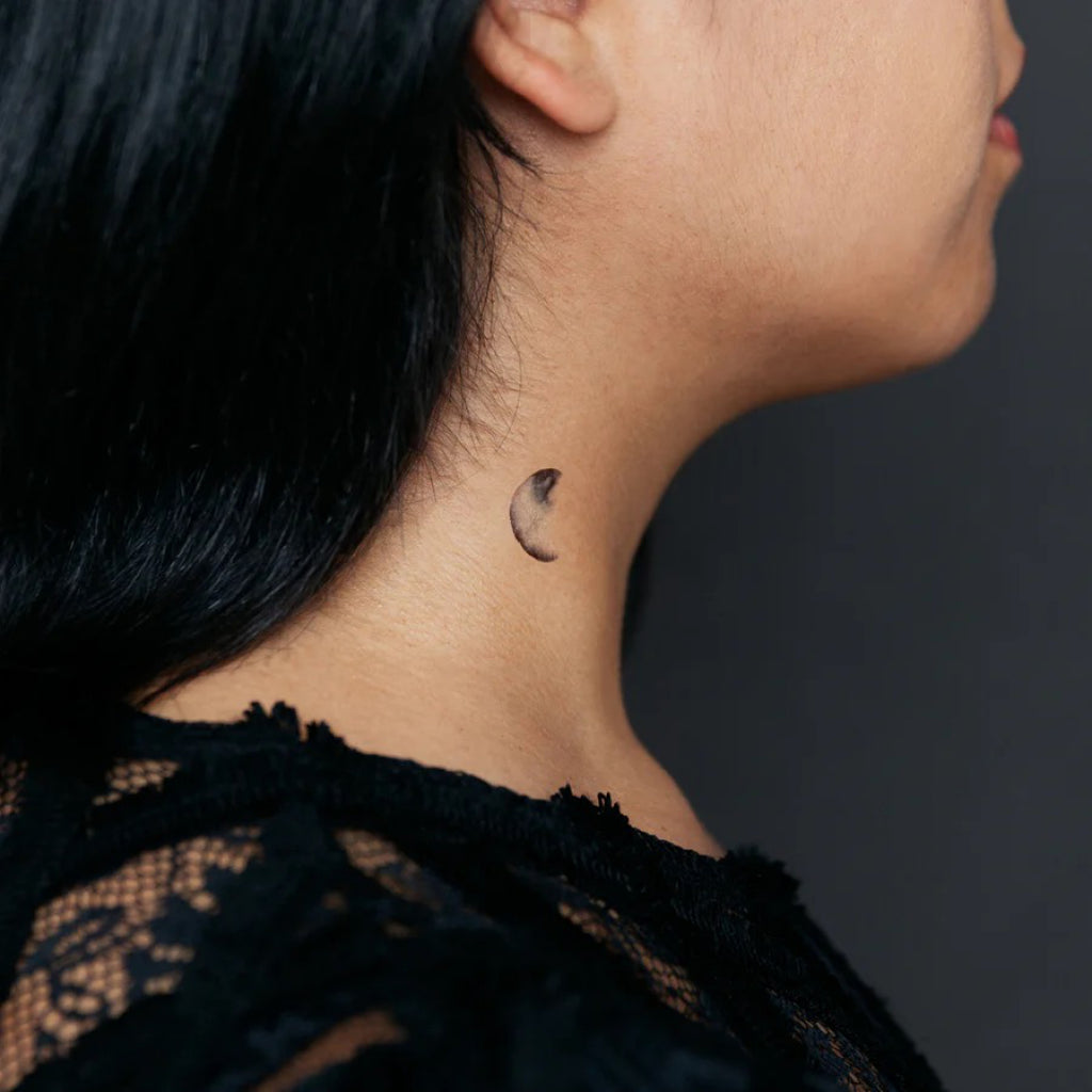 Moon phase temporary tattoo on neck.