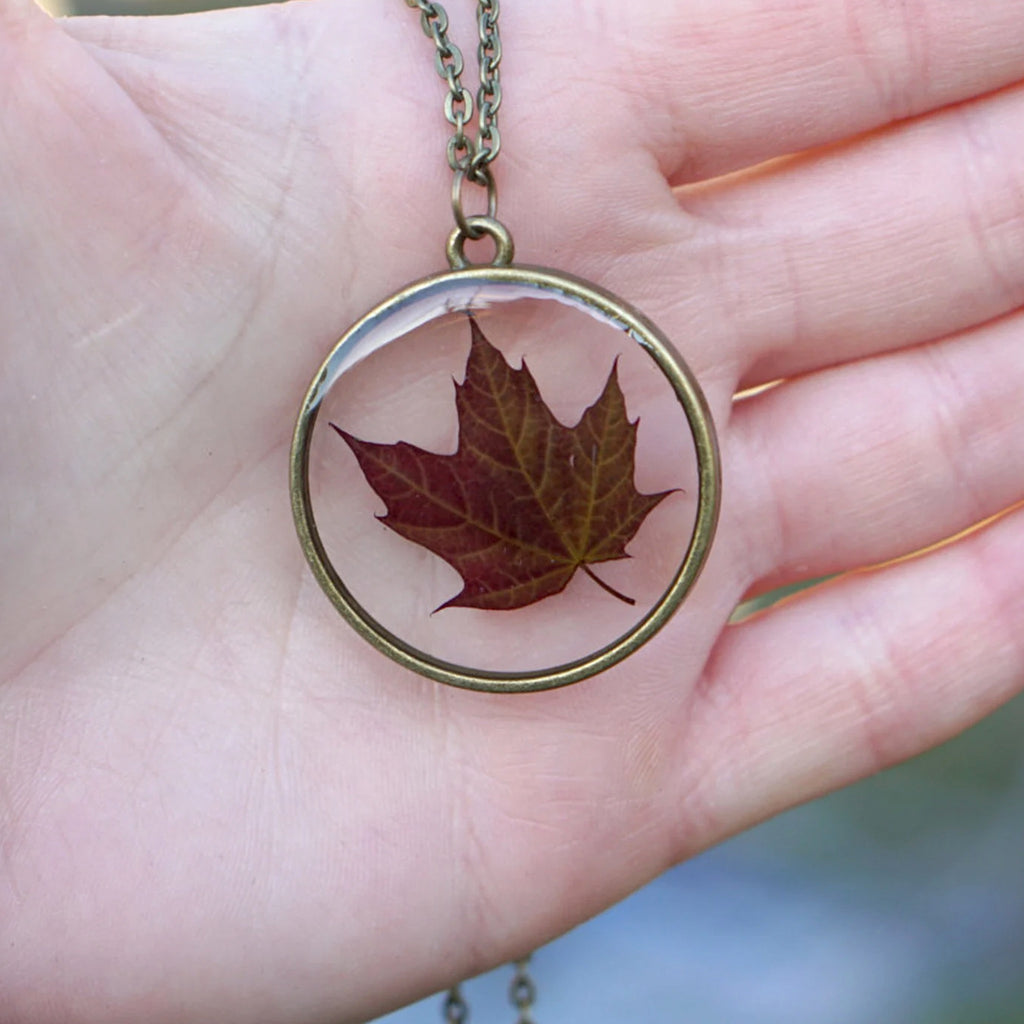 Person holding Red Maple Leaf Necklace.
