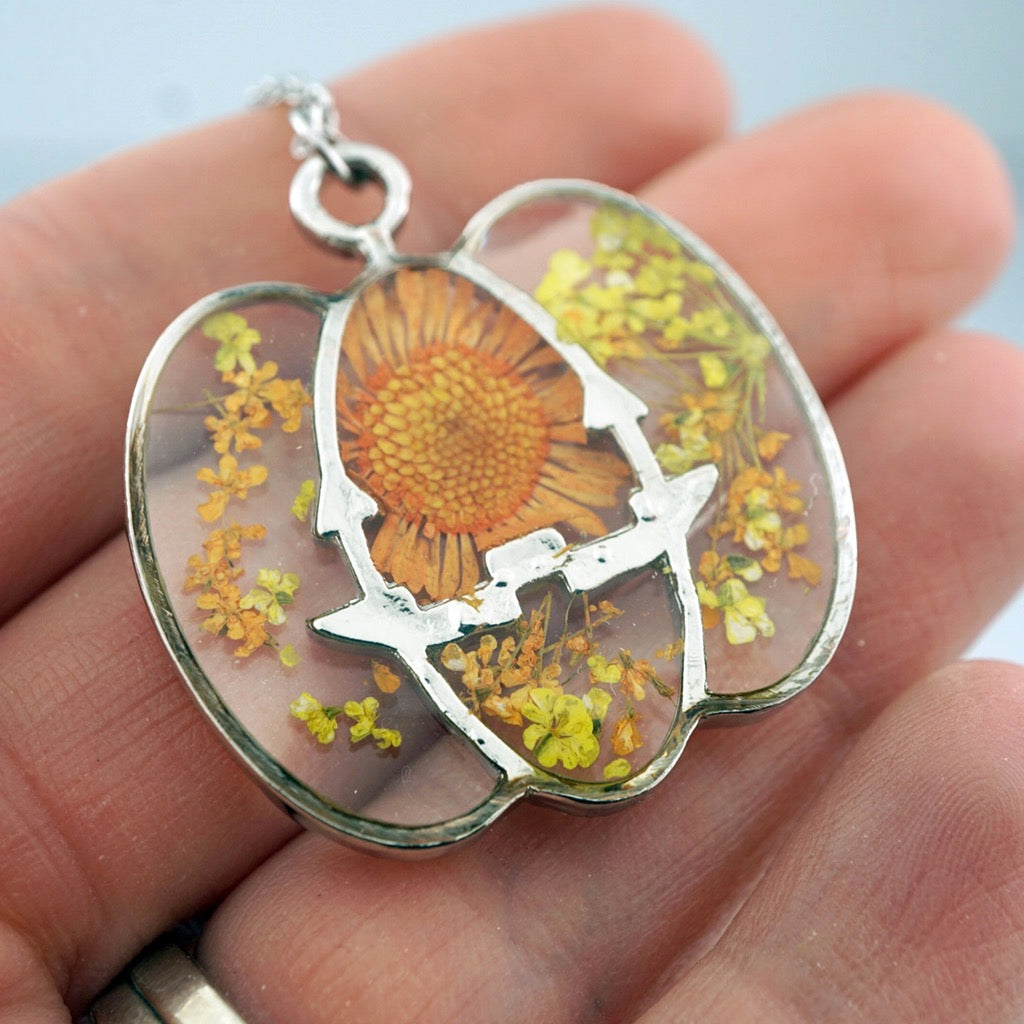 Person holding Silver Pumpkin Flower Necklace.
