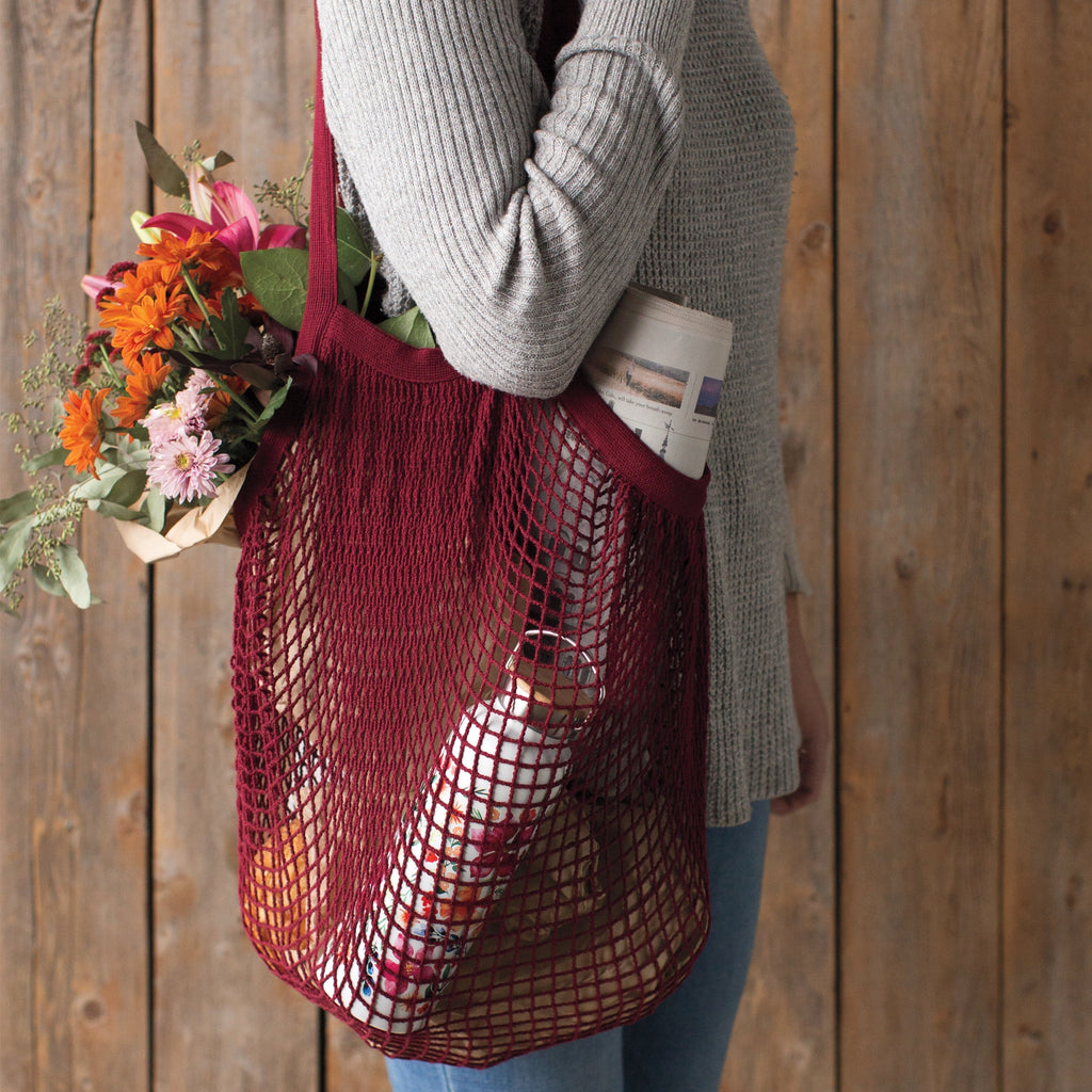 Person using Le Marche String Shopping Bag Plum.