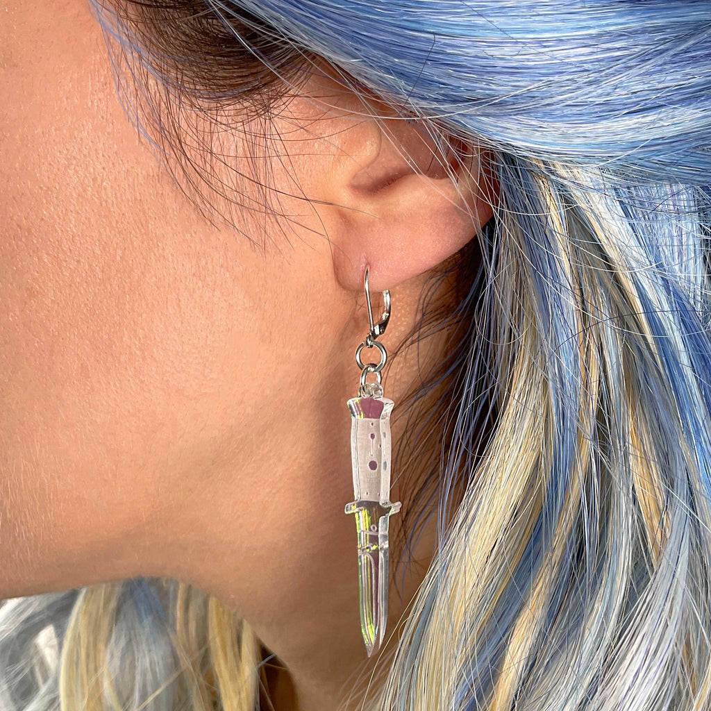 Person wearing A Knife Less Ordinary Iridescent Hook Earrings.
