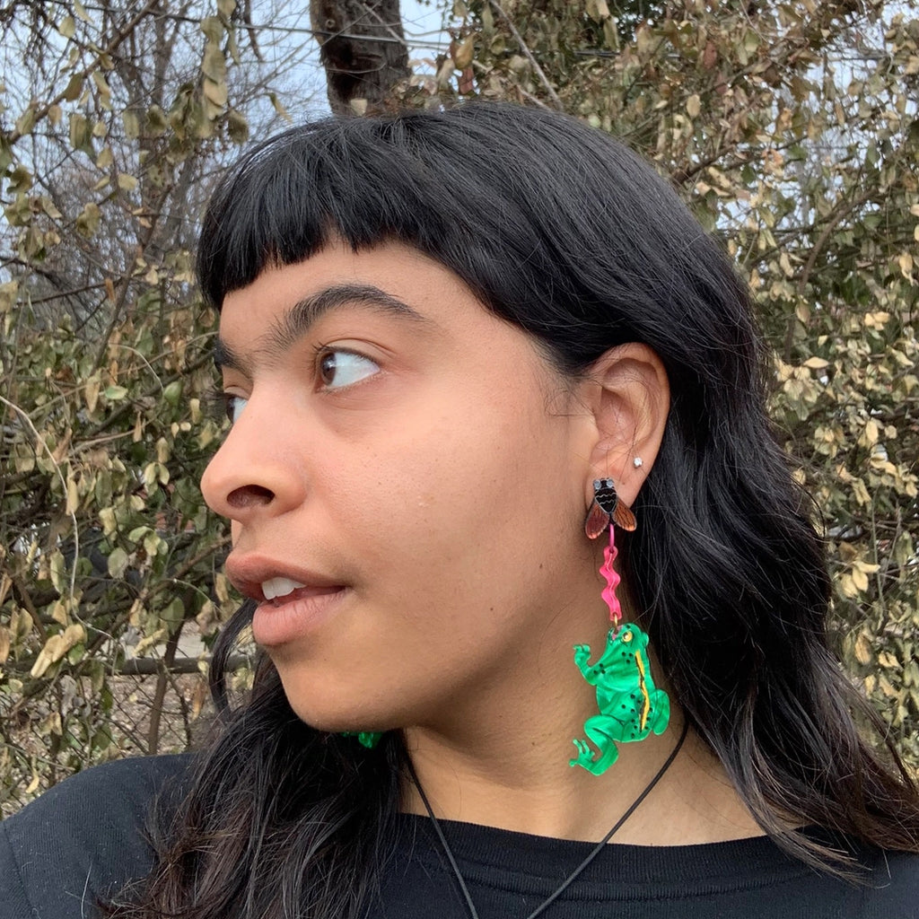 Person wearing Animal Kingdom Frog and Fly Earrings.