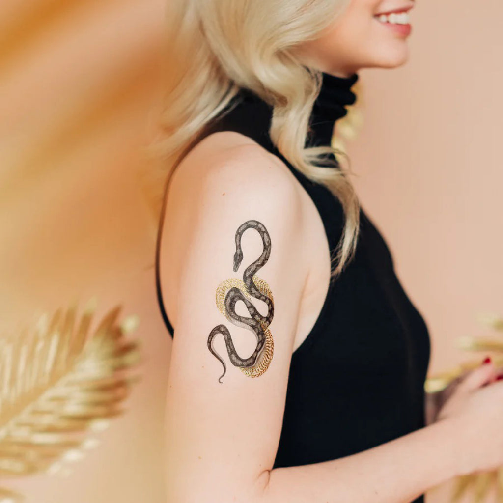 Shimmering Serpent Gold Tattoo on arm.