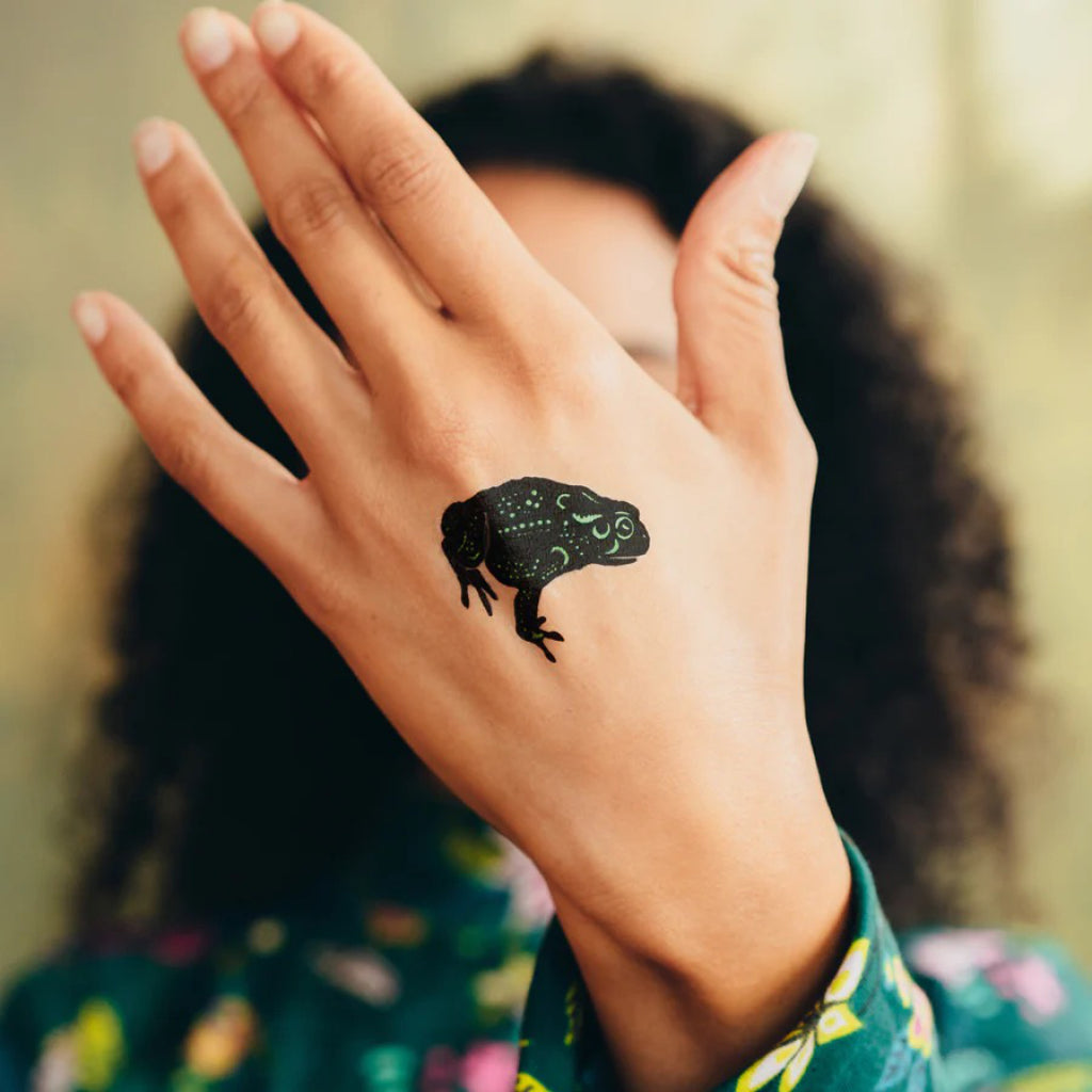 Speckled Metallic Frog Tattoo on hand.