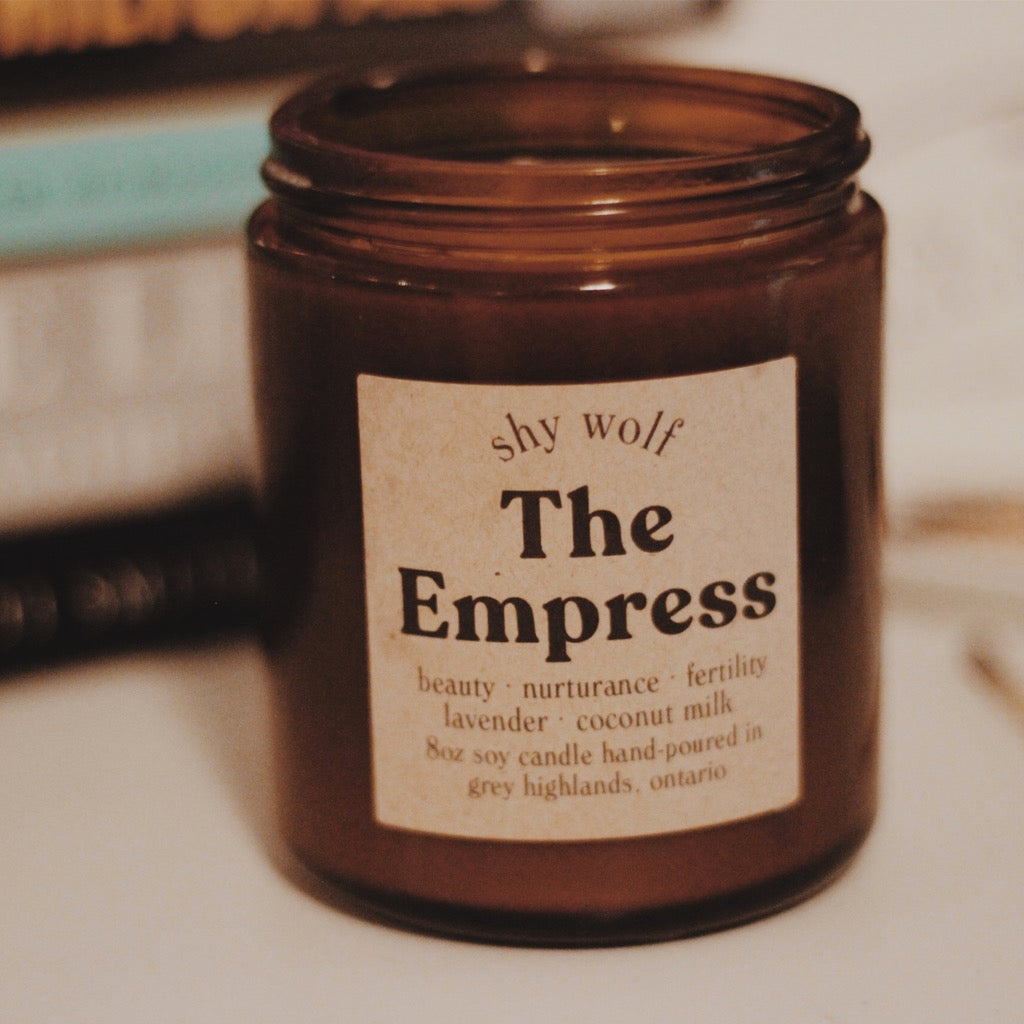 The Empress Tarot Candle in front of books.