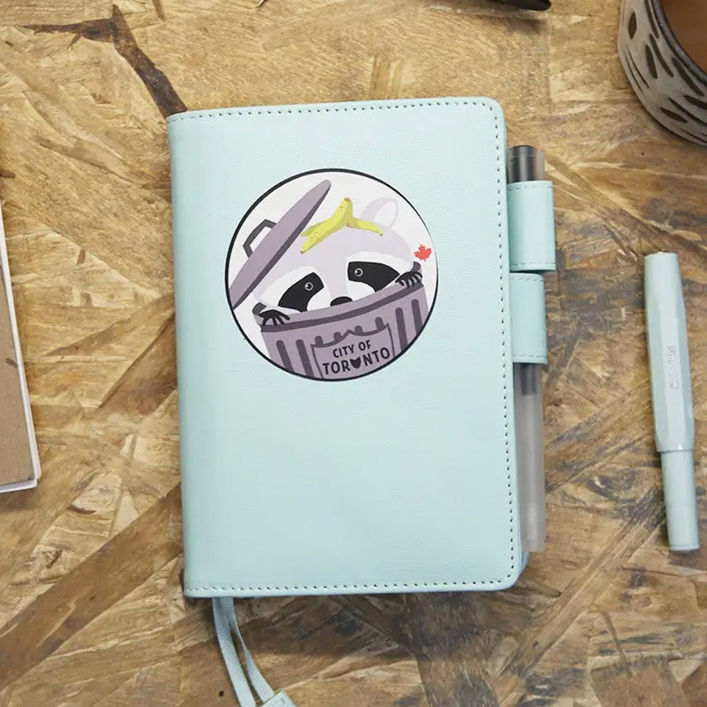 Trash Panda Raccoon Round Sticker on journal.
